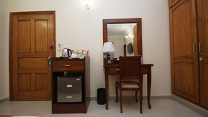 Comfortable hotel room with a wardrobe, desk, and mirror.
