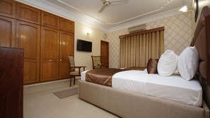Relax in comfort with a large bed, wardrobe, and wall-mounted TV.