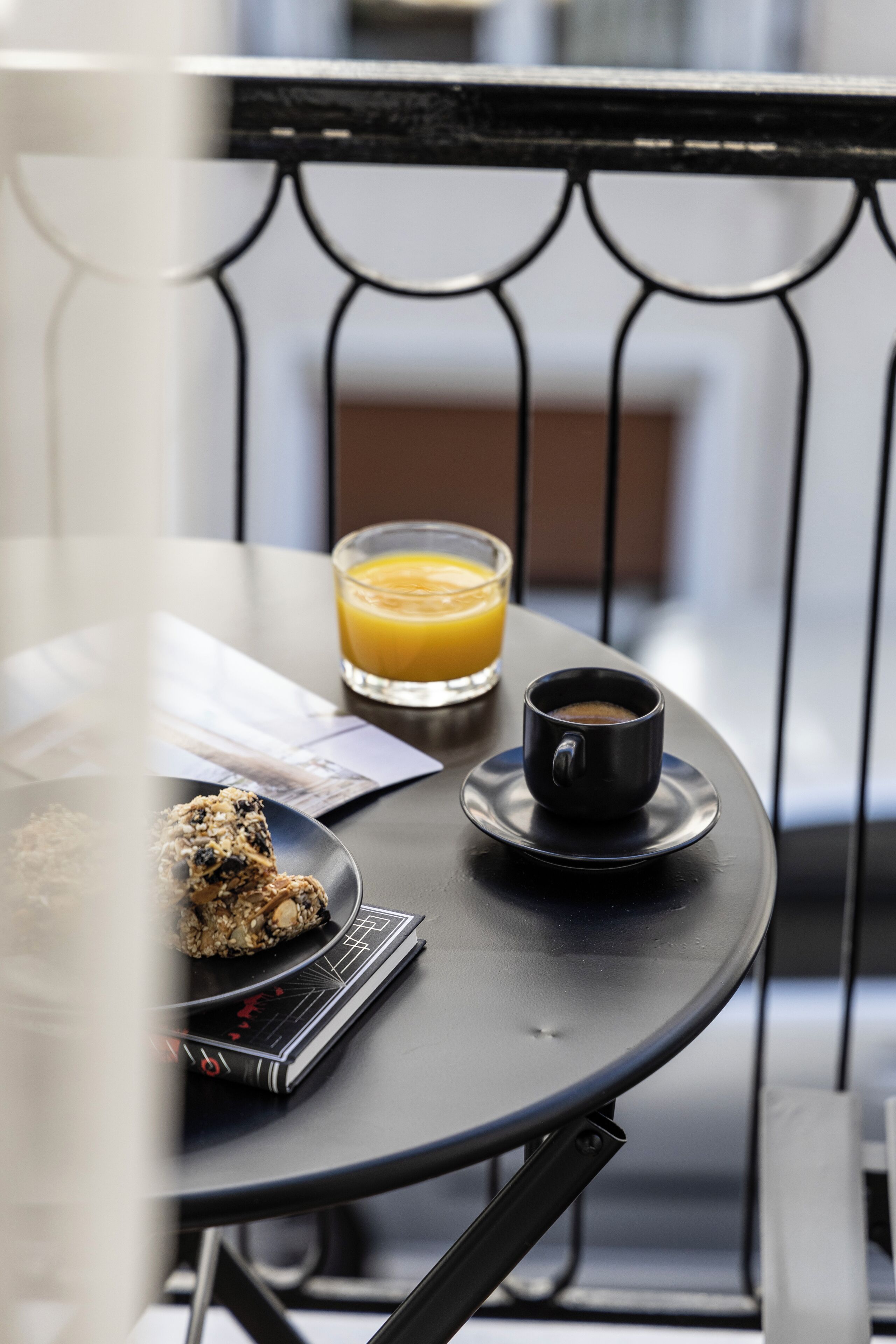 Une table avec un verre de jus d’orange, une tasse de café et une assiette de nourriture.