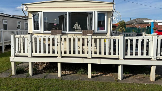A mobile home with a covered porch and a fenced deck. - 6 Berth Caravan Next To The Beach-ingoldmells-dog Friendly (Skegness)
