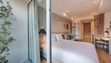 Ein modernes Schlafzimmer mit einem großen Bett, Nachttischen, einem Schreibtisch und einem Sessel.
