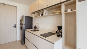 A modern kitchen with a built-in refrigerator, a sink, and a coffee maker. - U-GO Porto Horizonte Junto al Mar Sta Mta (Santa Marta)