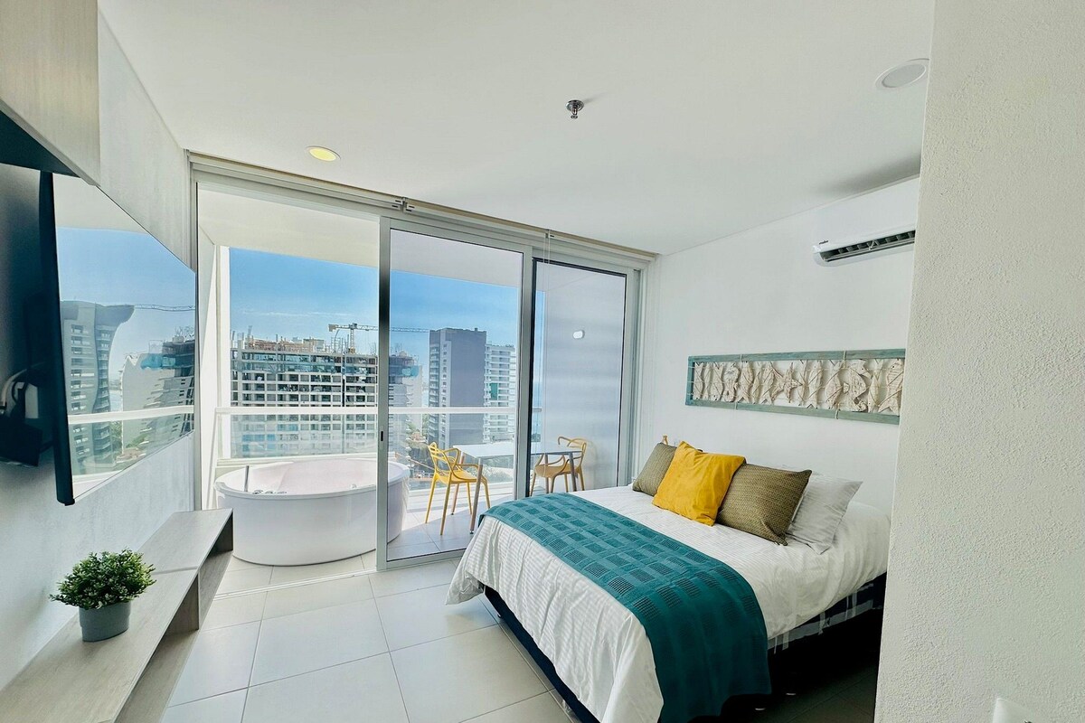Un dormitorio moderno con una cama grande, un balcón con vista a la ciudad y un ventanal corredero.