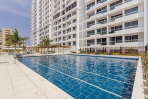 Um hotel moderno com piscina, várias varandas e terraço no terraço.