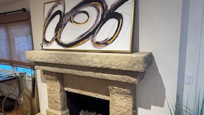 A stone fireplace with a large abstract painting above it.