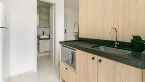 A modern kitchen with a built-in microwave, a sink, and wooden cabinets.