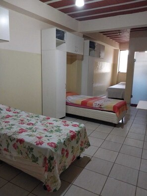 A bedroom with a bed, a wardrobe, and a small bedside table. - Pousada Amigo João (Barao de Cacais)