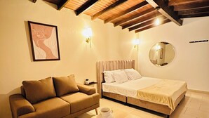 Un dormitorio acogedor con techo de madera, cama, sofá y una mesita de centro.