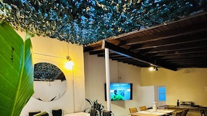 Un área de spa con jacuzzi, asientos de madera y televisor.