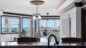 A modern kitchen with a large window overlooking the ocean, a marble countertop, and a ceiling fan. - Gorgeous Condo at Mediterranea! (Miramar Beach)