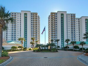 A modern high-rise building with multiple balconies and a central flagpole. - Luxury Penthouse at Silver Beach Towers! (Destin)
