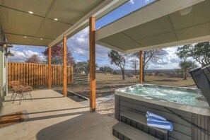 A covered outdoor area with a hot tub, wooden deck, and chairs. - Evergreen Escape: Hot-Tub,5 Min Downtown! (Fredericksburg)