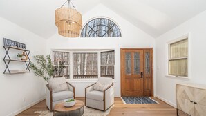 A cozy room with a large window, a wooden door, and a white wall with a 'LAKE LIFE' sign. - Lake Point Escape - Dock and Hottub on Belews Lake (Forsyth County)