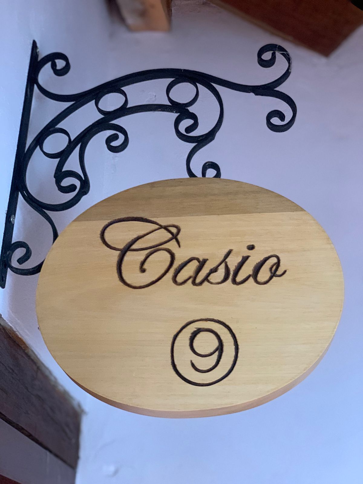 A wooden sign with 'Casio' and the number '9' engraved on it.