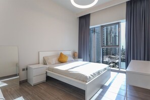 Ein modernes Schlafzimmer mit einem Bett, Nachttischen und einem großen Fenster mit Blick auf die Stadt.
