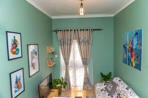 Relax in this stylish living room with a sofa, TV, and artwork on the walls.