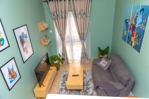Relax in this inviting living room with a comfortable sofa, flat-screen TV, and artwork on the walls.