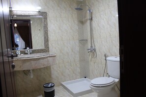 A bathroom with a shower, toilet, sink, and mirror. - Pioneer Hotel Apartments (Muscat)