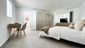 A bedroom with a bed, a TV, a desk with a chair, and a wardrobe. - Stunning Villa | Heated Pool - Pass the Keys (Mijas)