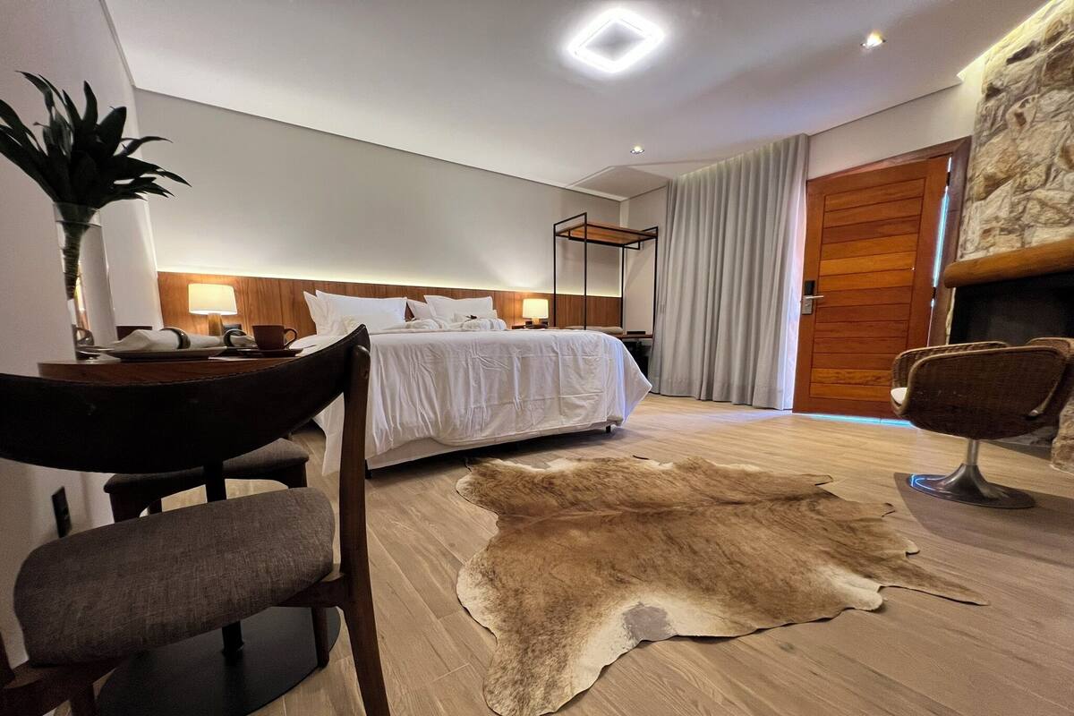 Une chambre d’hôtel moderne, équipée d’un lit, d’un bureau avec une chaise, d’un tapis en cuir et d’une porte en bois.