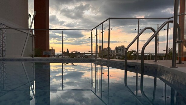 A swimming pool with a glass bottom, reflecting the sky and buildings. - U-GO Belmonte Armenia (Armenia)