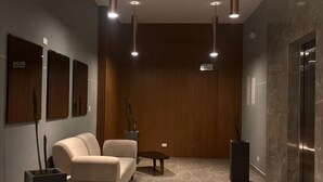 A modern lobby with a sofa, a coffee table, and potted plants. - U-GO Belmonte Armenia (Armenia)