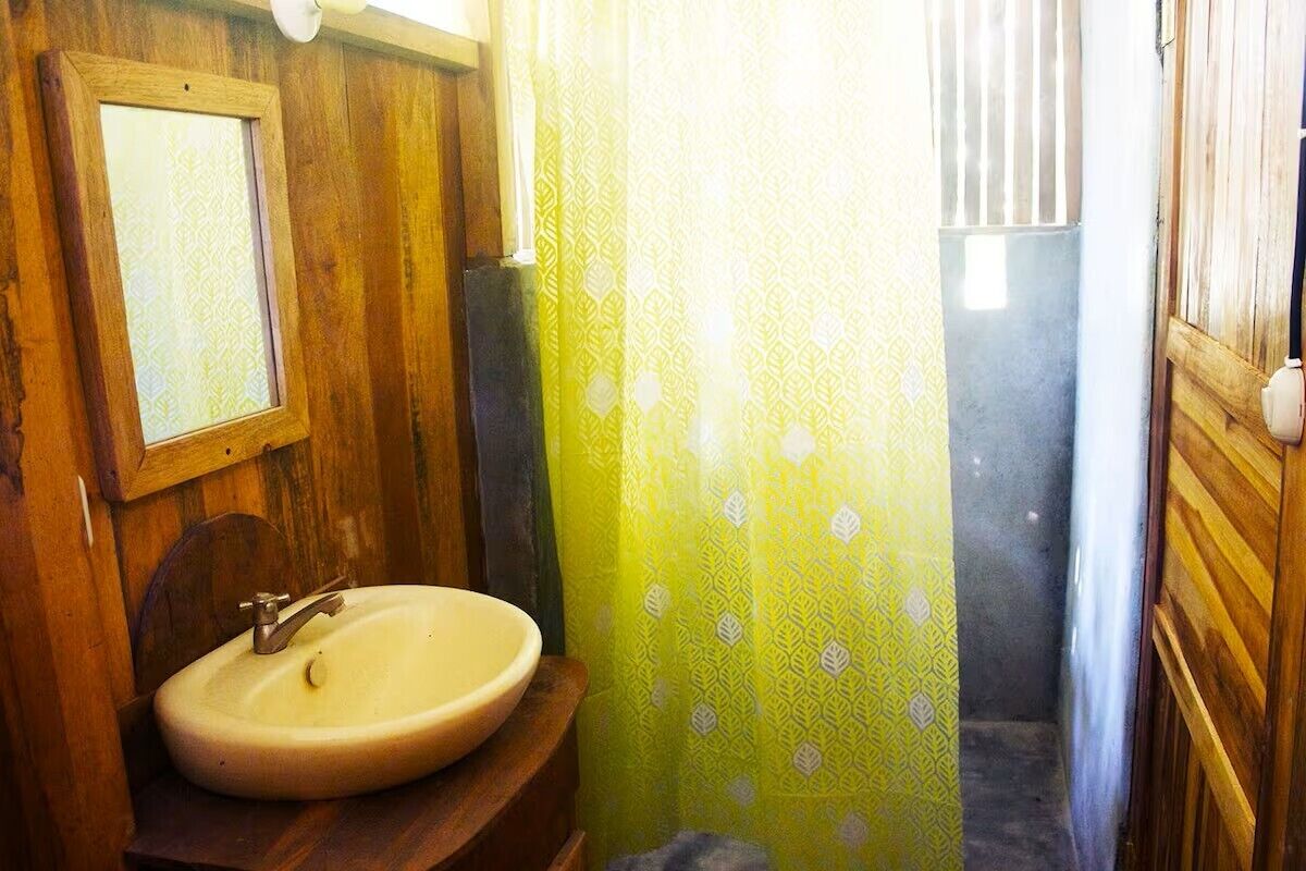 Une salle de bain avec un meuble-lavabo en bois, un miroir et un lavabo.