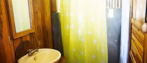 Une salle de bain avec un meuble-lavabo en bois, un miroir et un lavabo.