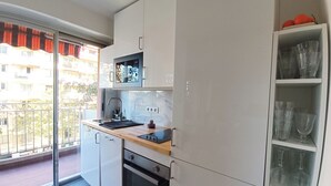 A compact kitchen with a built-in oven, a sink, and a small countertop. - 2-rooms apartment - Wifi and balcony (Nice)