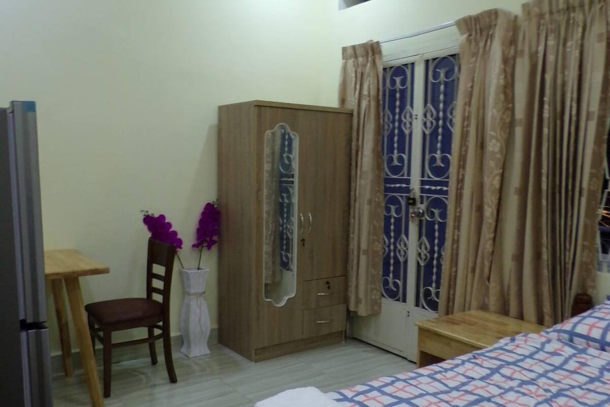 Un dormitorio con cama, armario, escritorio y silla.