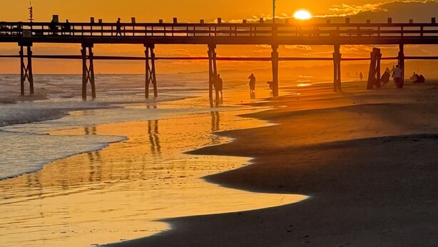 A beach scene with a pier extending into the water. - Experience the Wild Beauty of Sunset Village from Your Private Balcony (Sunset Beach)
