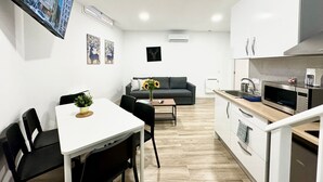 Ein modernes Apartment mit Essbereich, einer Couch und einer Küche.