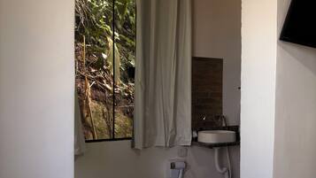 Un baño con ventana, lavamanos y secador de pelo.