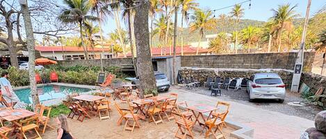 A poolside area with lounge chairs, a Coca-Cola branded cooler, and a stone wall in the background.
