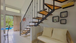 A modern interior with a staircase, a sofa, and a dining area.