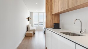 Una cocina moderna con un lavaplatos integrado, armarios de madera y vistas de la ciudad a través de amplias ventanas.
