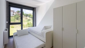 A bedroom with a bed, a wardrobe, and a large window with a view of a garden and buildings. - Urbanfive 4A Ourense downtown 3 rooms (Ourense)
