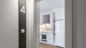 A modern kitchen with white cabinets, a built-in oven, and a refrigerator. - Urbanfive 4A Ourense downtown 3 rooms (Ourense)