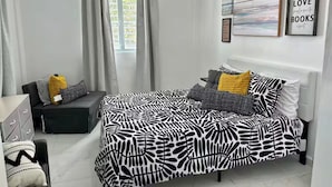 Un dormitorio moderno con cama, escritorio y silla.