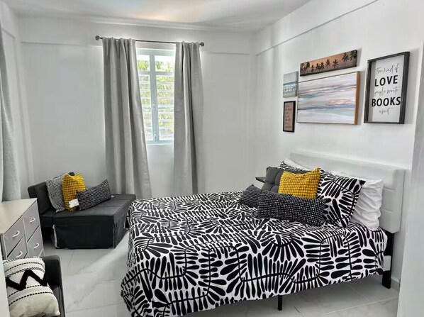 Un dormitorio moderno con cama, escritorio y silla.