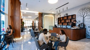 A modern cafe with wooden accents, a coffee bar, and a seating area with tables and chairs. - ADAY Hotel Casablanca (Casablanca)