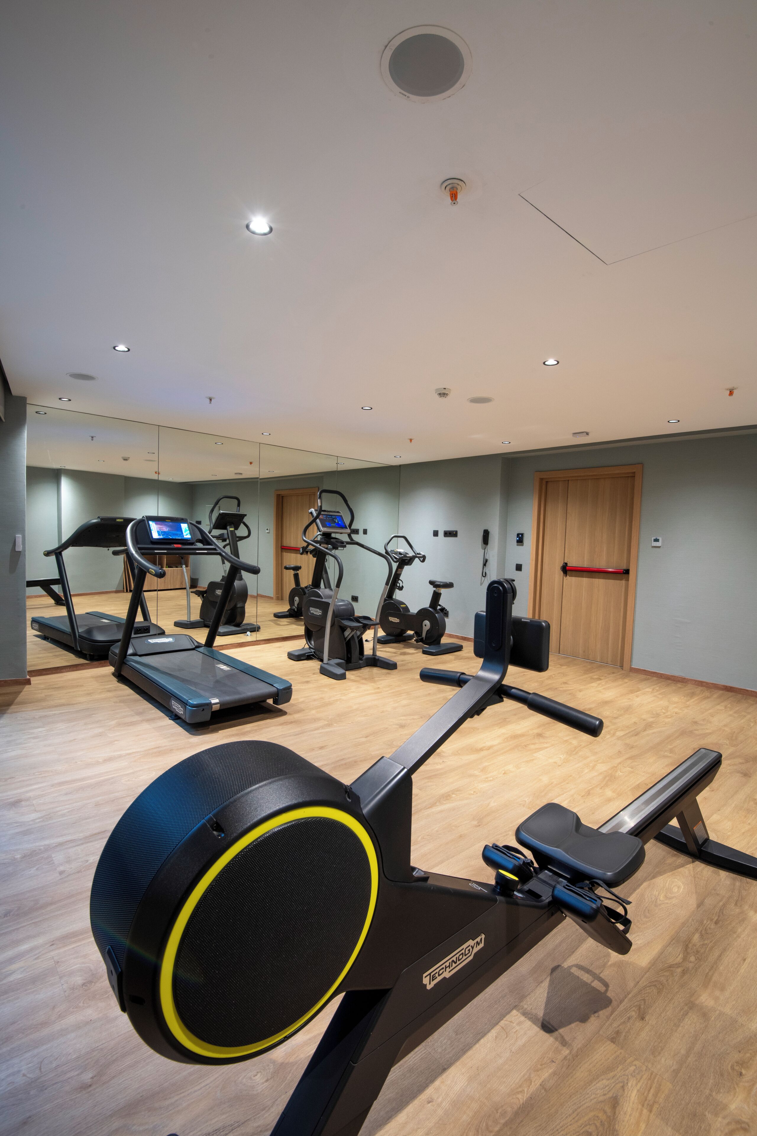 A gym with treadmills, elliptical machines, and stationary bikes.