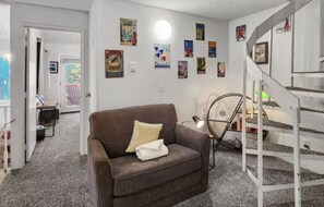 A living room with a brown sofa, a white lamp, and a staircase with a white railing. - Baldy Mountain Basecamp - Pet Friendly! - Free Shuttle Access (Breckenridge)