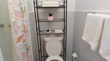 Chuveiro, toalhas de banho, sabonete, papel higiênico