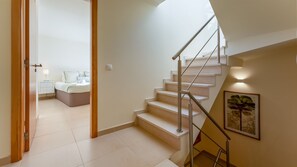 Un interior moderno con una escalera que lleva a un dormitorio.