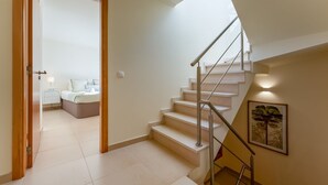 A modern interior with a staircase leading to a bedroom.