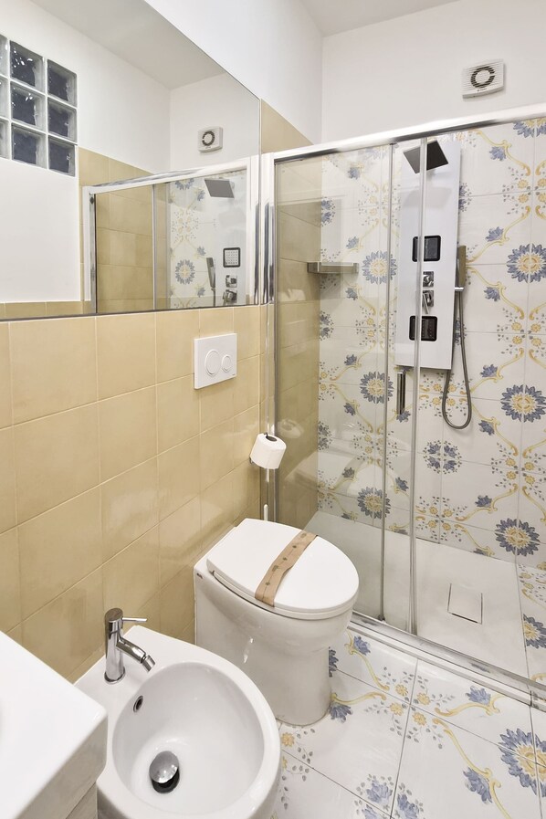 Une salle de bain comprenant des toilettes, un lavabo et un espace douche.