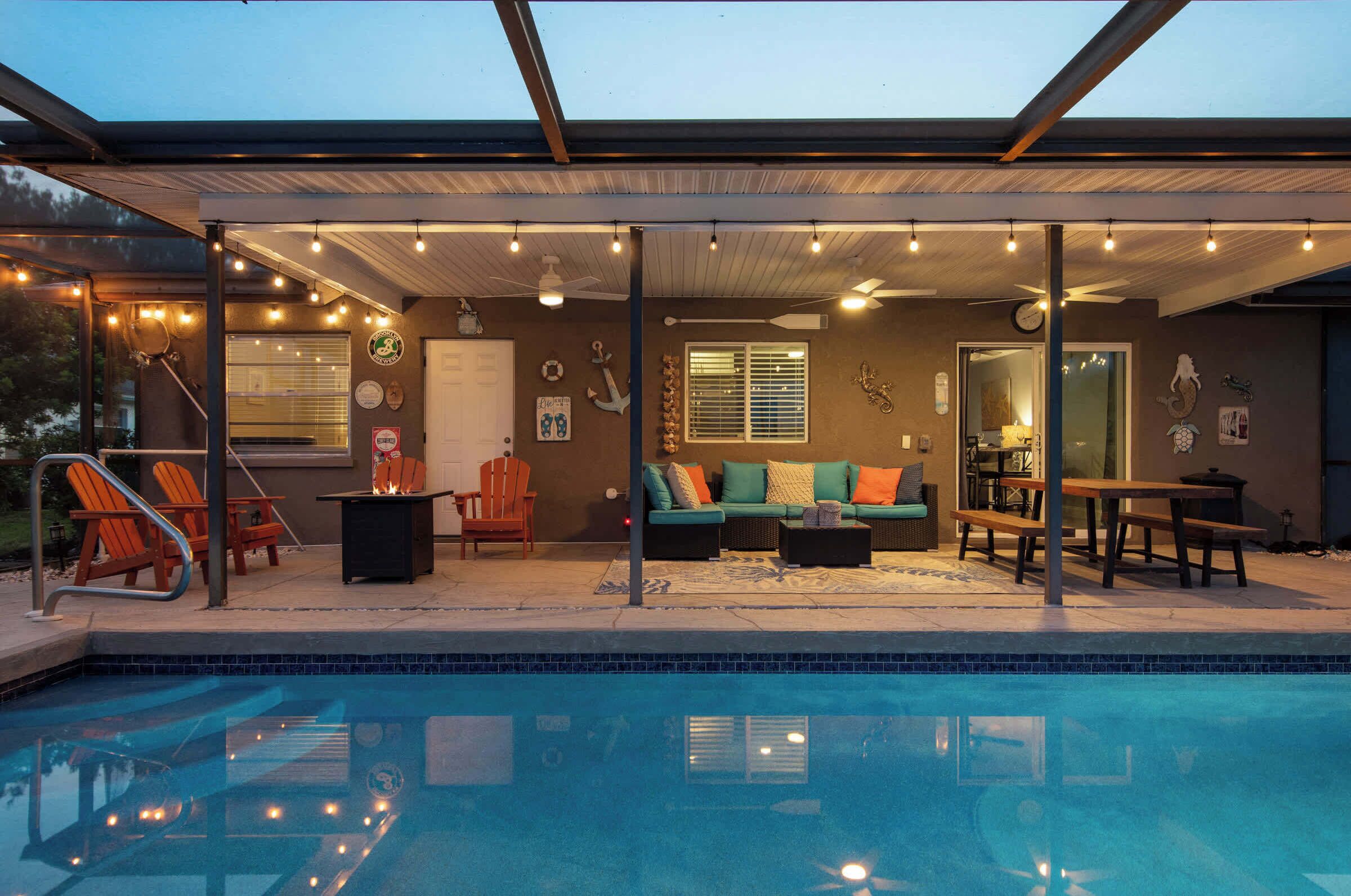 Uma área de piscina ao ar livre com espaço coberto para sentar, mesa de bilhar e bar.
