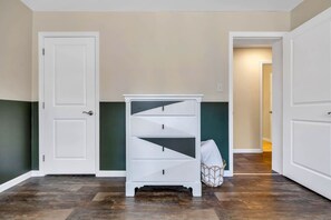 A hallway with a white storage unit, a door, and a bag on the floor.