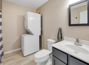 A bathroom with a toilet, a sink, and a mirror.